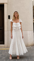 Front view of woman wearing white ruffled two-piece maxi set