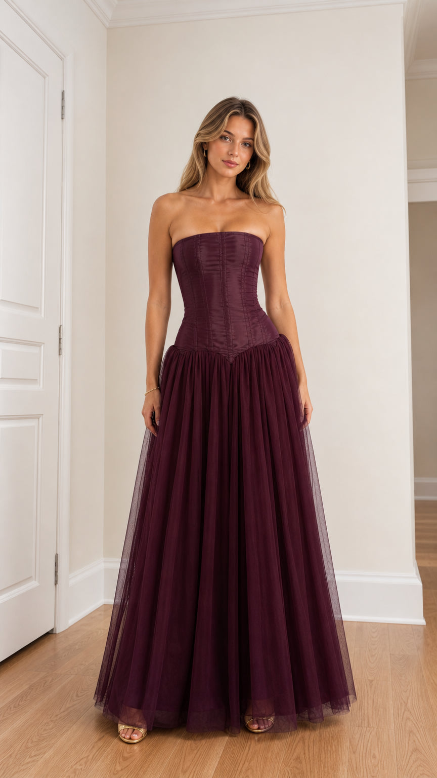 Front view of woman wearing burgundy strapless corset tulle maxi dress
