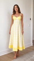 Front view of woman wearing yellow gingham midi sundress