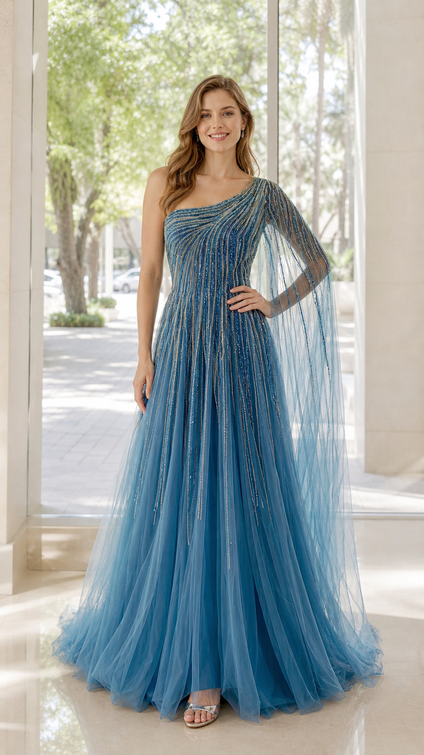 Front view of model wearing blue one-shoulder beaded tulle evening dress with cape sleeve