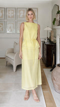 Front view of woman wearing yellow sleeveless tiered maxi dress