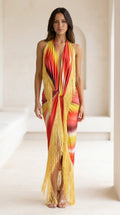 Front view of model wearing red gradient halter maxi dress with yellow fringe