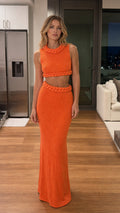 Front view of model wearing vibrant orange braided trim knit crop top and maxi skirt set