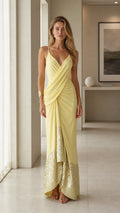 Front view of woman wearing yellow draped sequin maxi dress