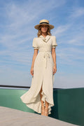 Front view of woman wearing cream polka dot maxi dress with hat