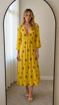 Front view of model wearing yellow embroidered midi dress