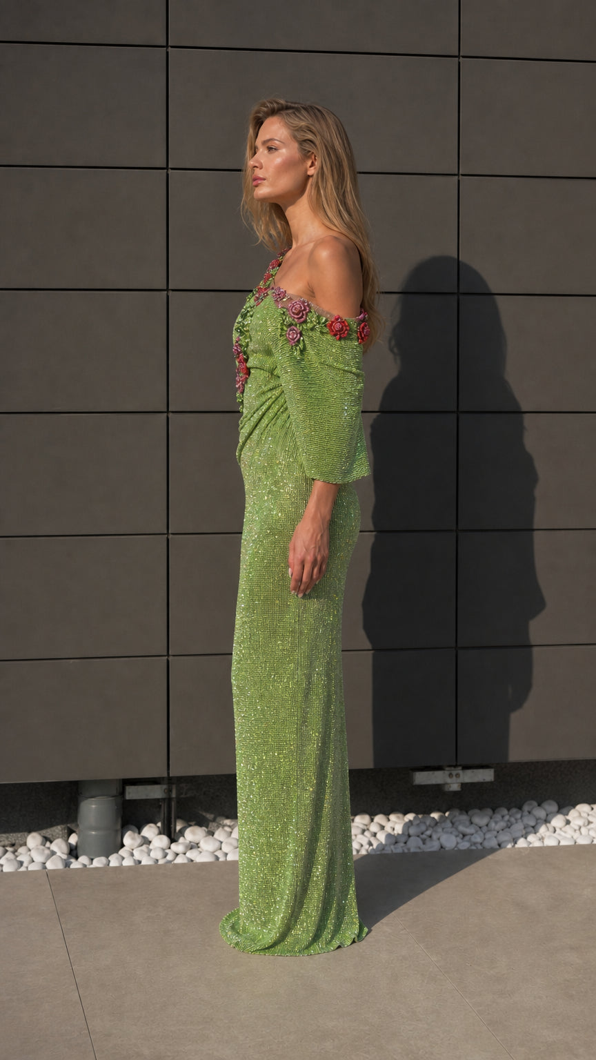 Side profile of model wearing green embellished evening dress