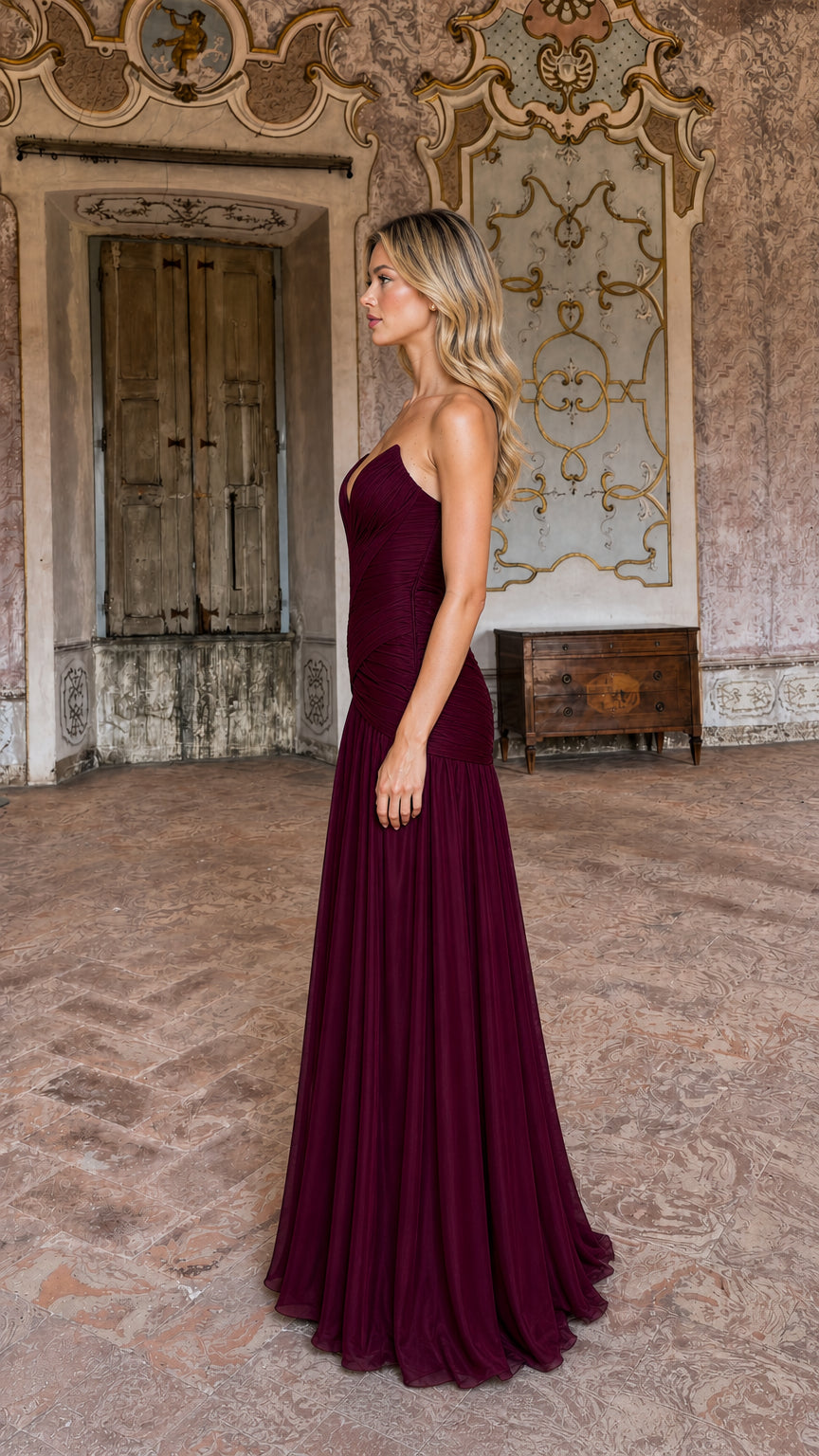 Side profile of model in burgundy evening gown showing fitted silhouette
