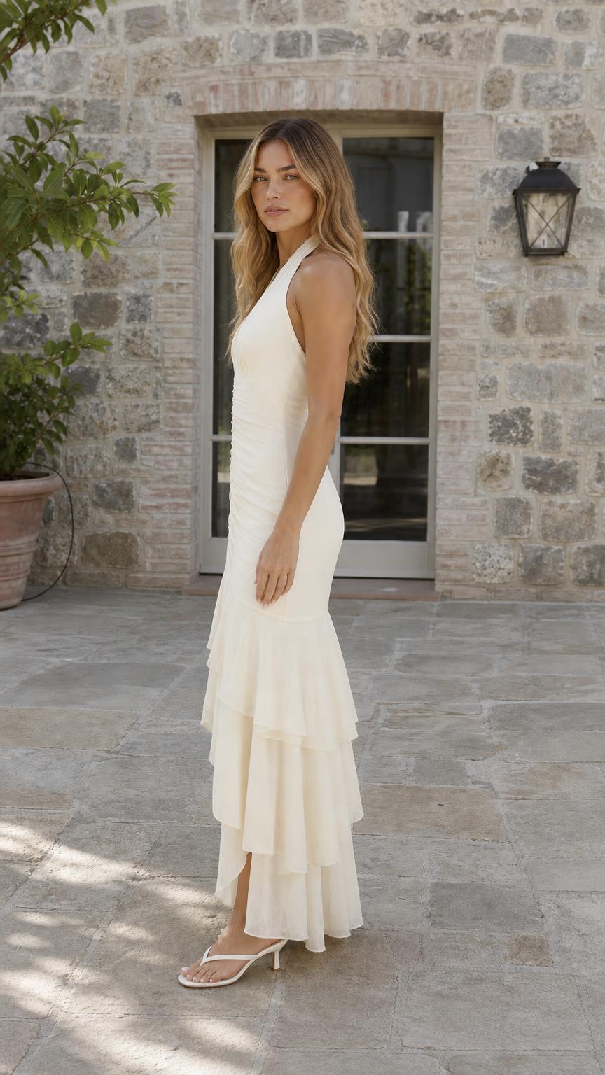 Side profile view of cream halter maxi dress
