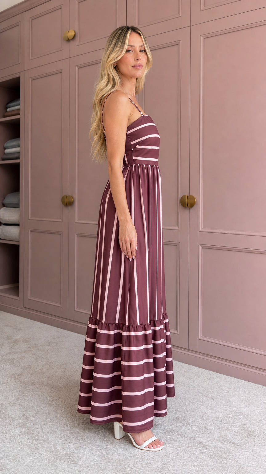 Woman wearing burgundy striped maxi dress side view