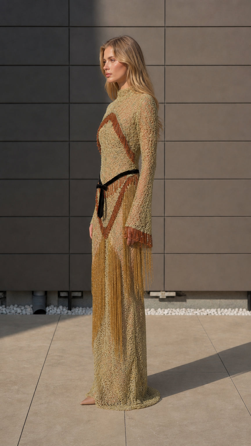 Side profile of model in gold fringe maxi dress