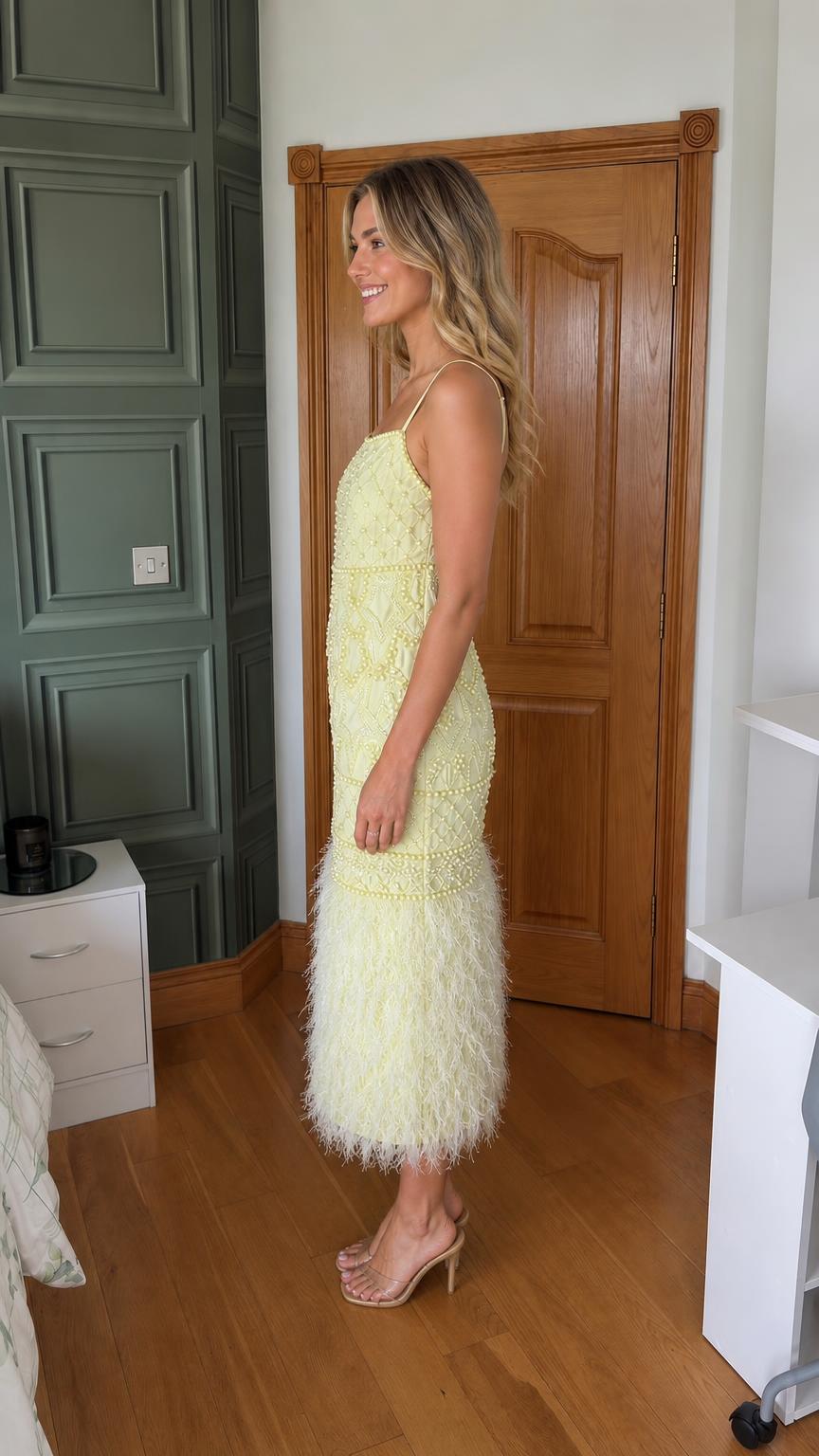 Side profile view of yellow feather trim midi dress