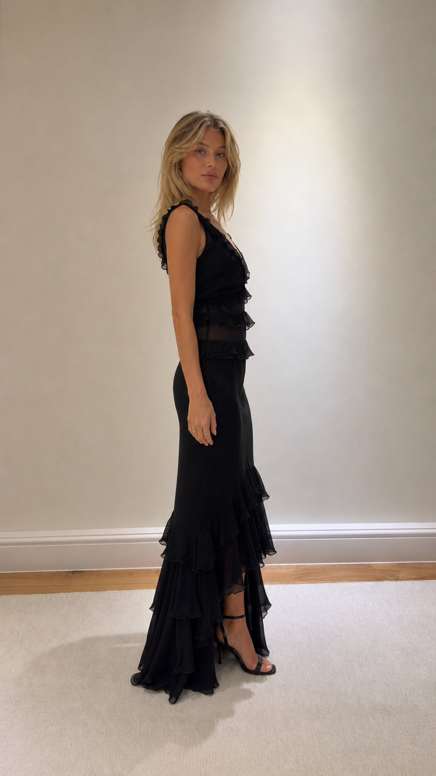 Side profile of black ruffled maxi dress with heels