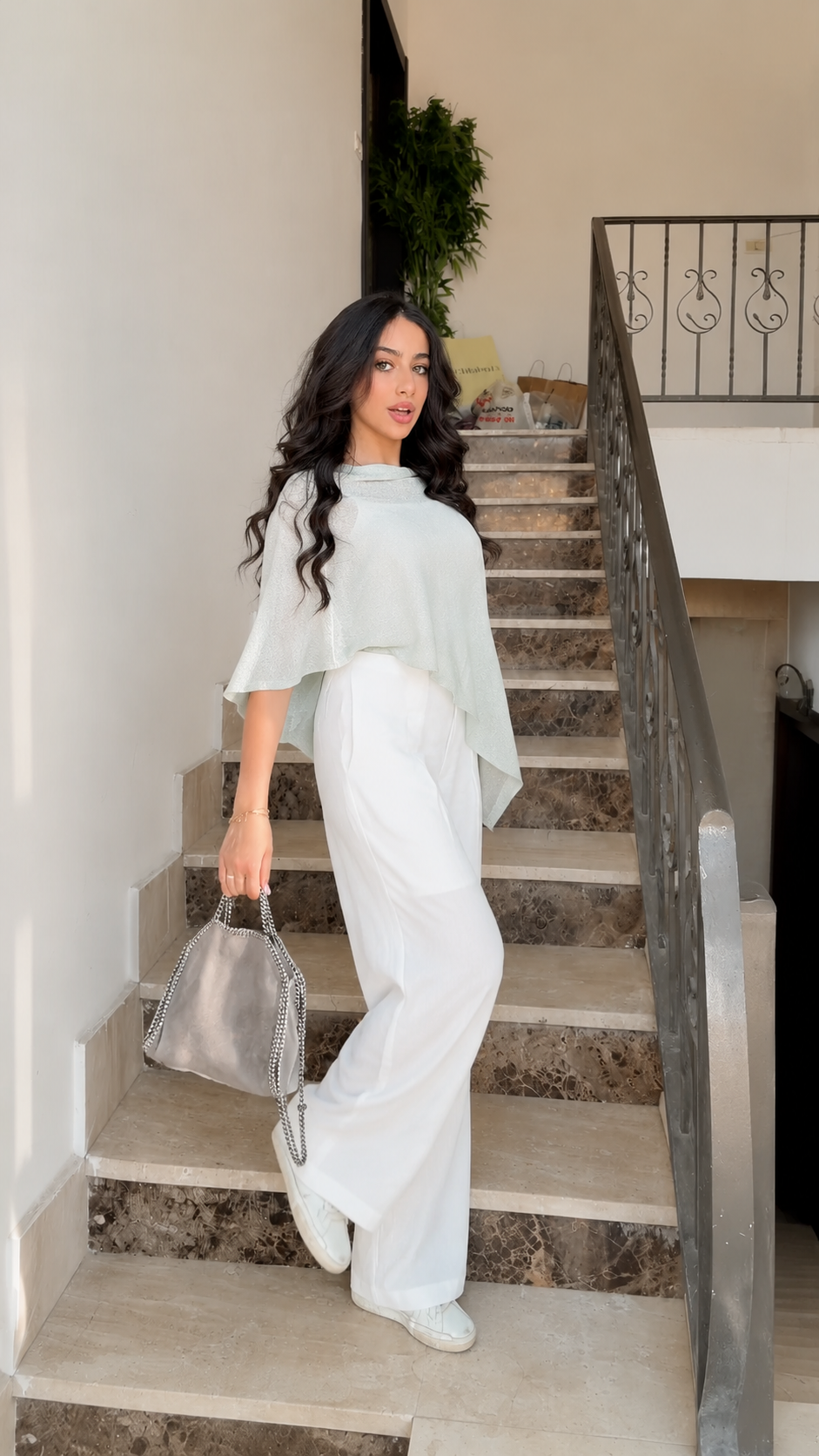 Side view of sage boat neck poncho knit top with flowing asymmetrical hem