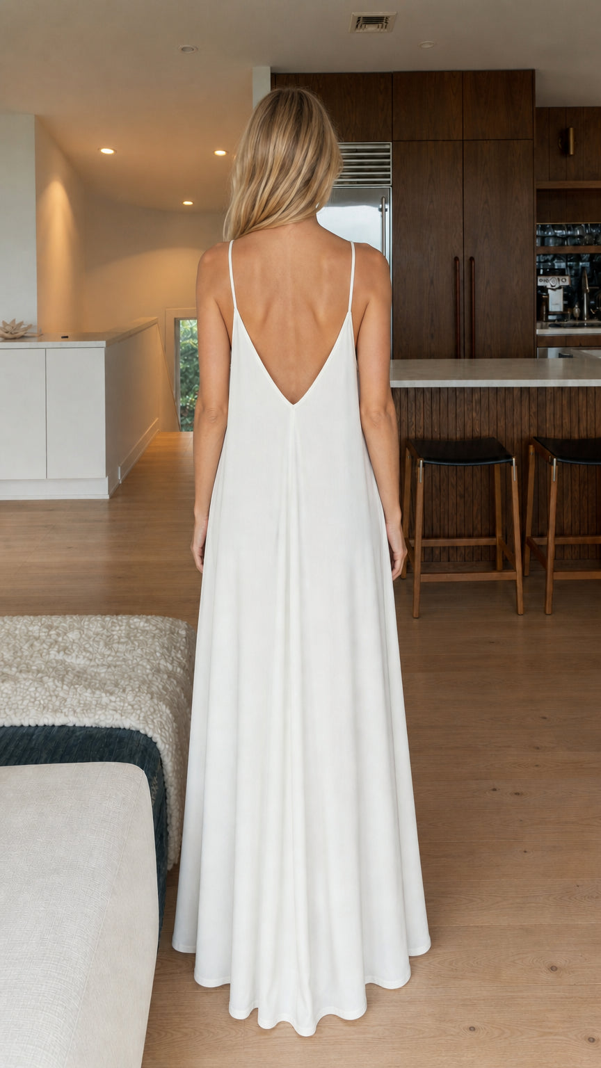 Model wearing white maxi dress, back view showing V-cut