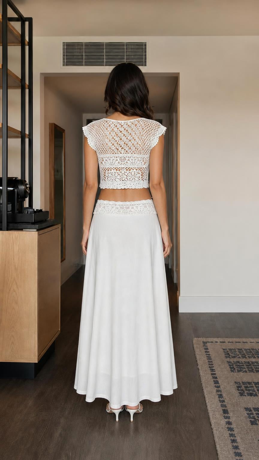 Back view of model in white two-piece crochet outfit