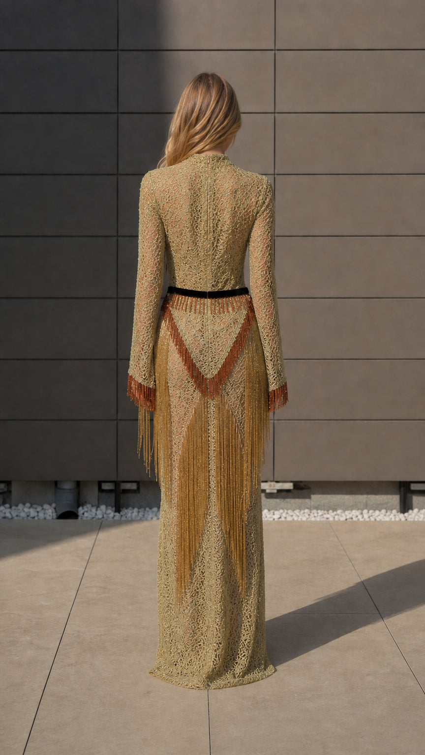 Back view of model in gold long sleeve maxi dress