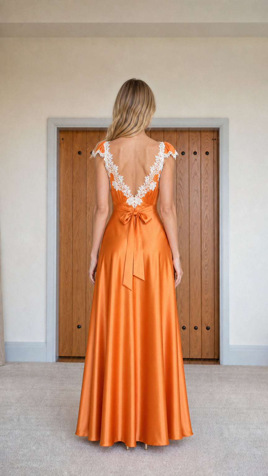 Back view showing self-tie bow and lace details on orange maxi dress