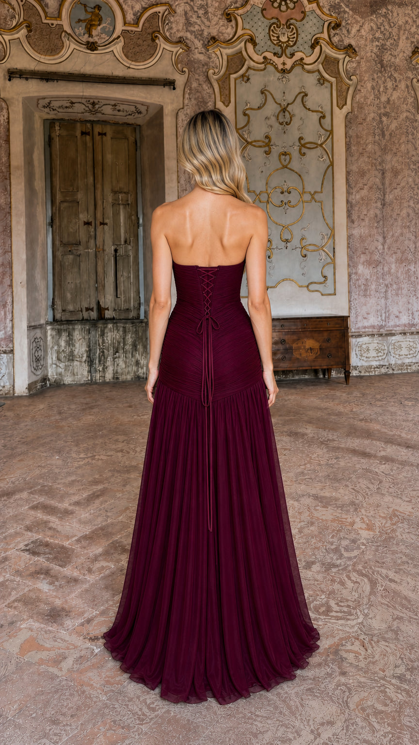 Back view of burgundy strapless dress featuring lace-up corset detail