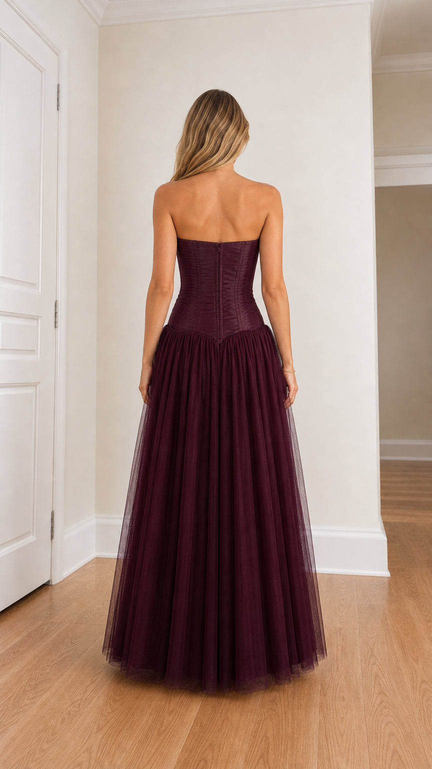Back view of woman in burgundy strapless corset tulle maxi dress
