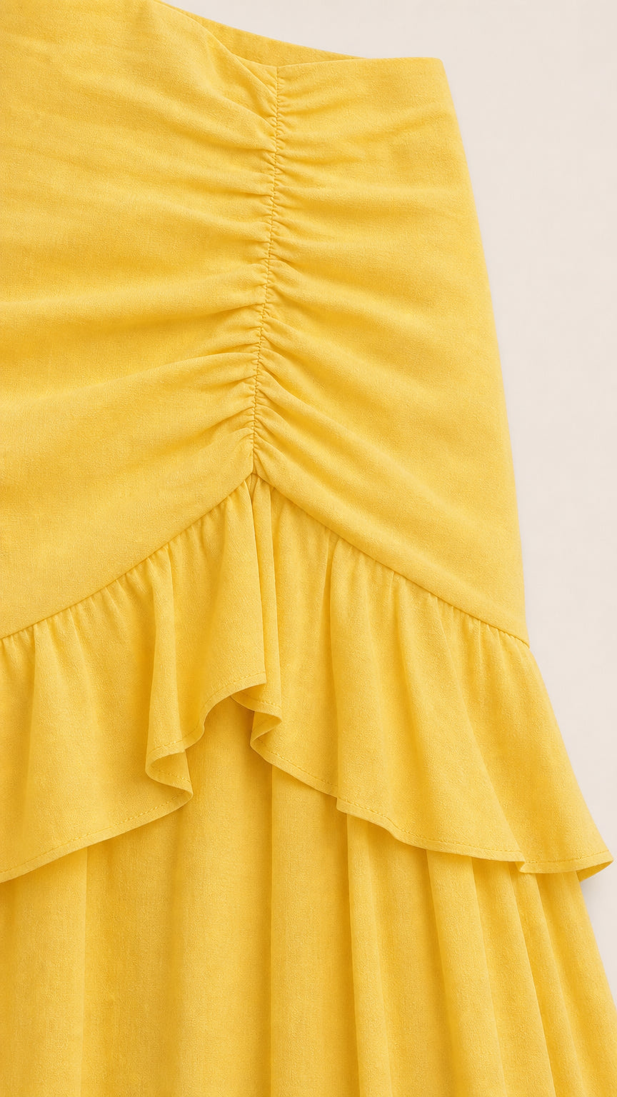 Close-up of ruched front texture and ruffle tier on yellow dress