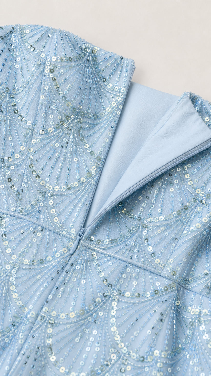 Close-up detail of sequin pattern and zipper closure on light blue dress