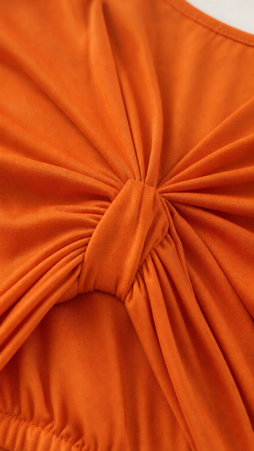 Close-up detail of the front twist knot and gathered texture on the orange dress