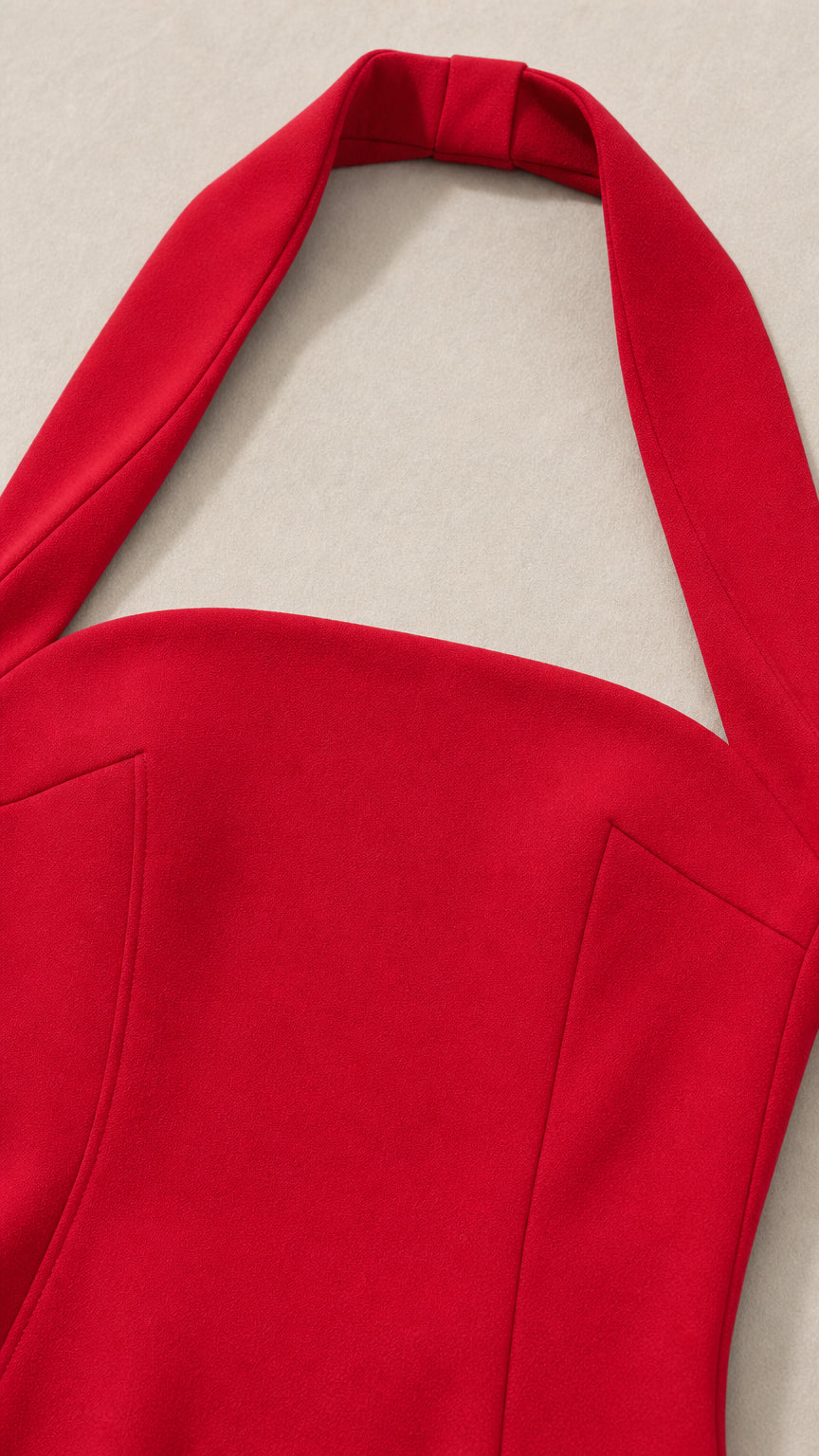 Close-up detail of red halter neck strap and bodice