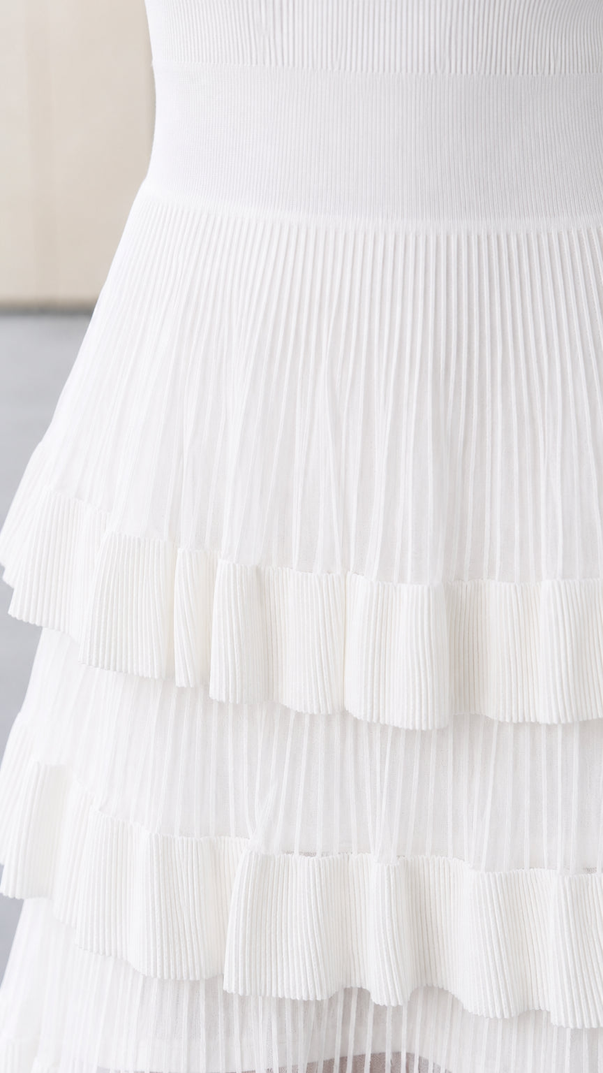 Close-up detail of pleated ruffle tiers and knit texture in white