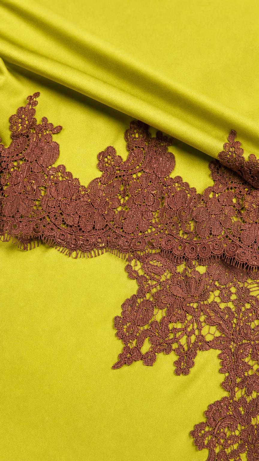 Close up of lime green smooth fabric and dark brown lace trim detail