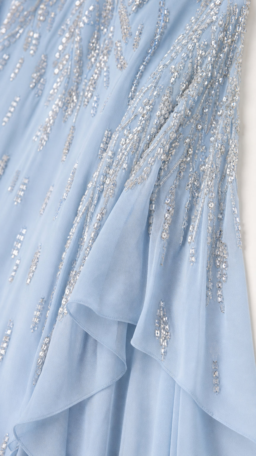 Close-up of silver sequin and bead embroidery on light blue fabric