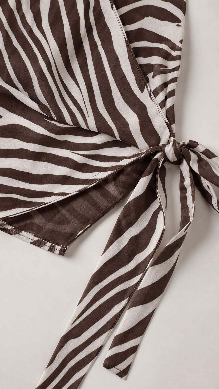 Close-up detail of smooth woven zebra print fabric and tie closure