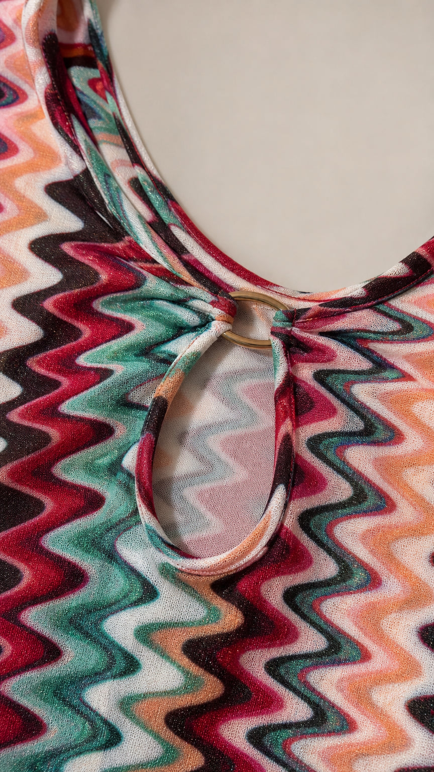 Close-up detail of neckline, ring, and cutout on chevron dress