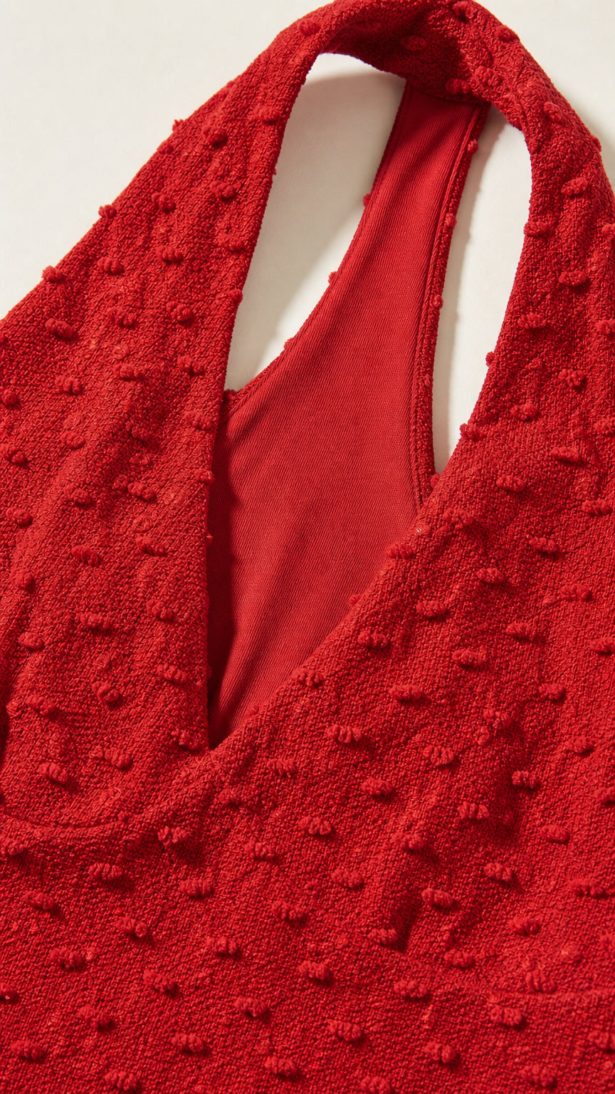 Close-up of red textured fabric and halter neckline construction