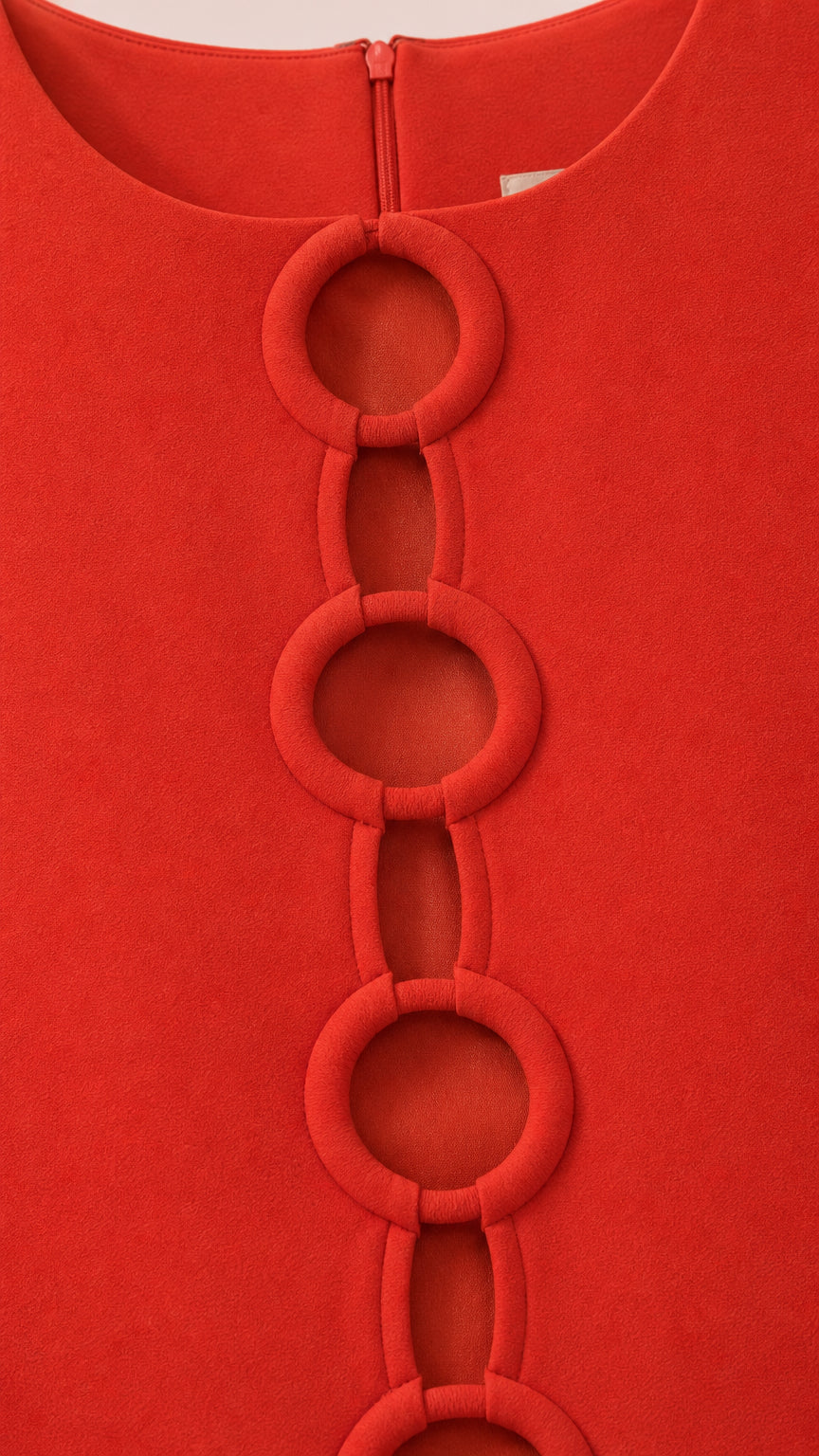Close-up of the front ring cutout details on red dress fabric