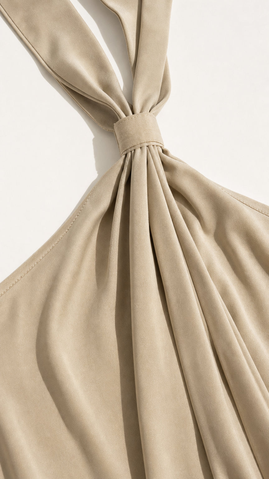 Close-up detail of halter neck strap and draping in beige