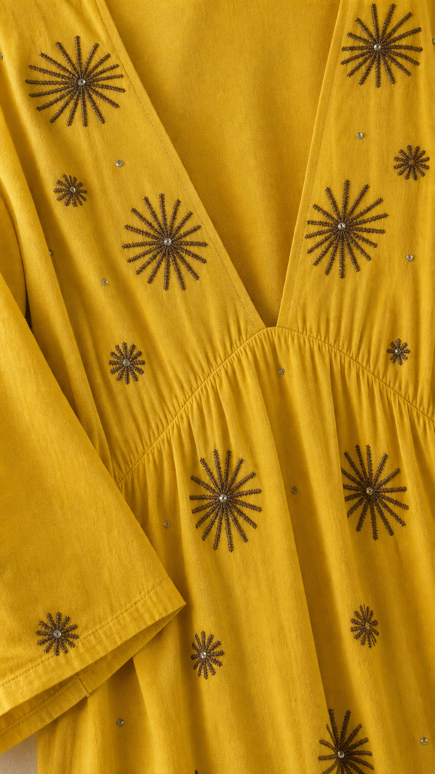 Close-up detail of V-neck and starburst embroidery