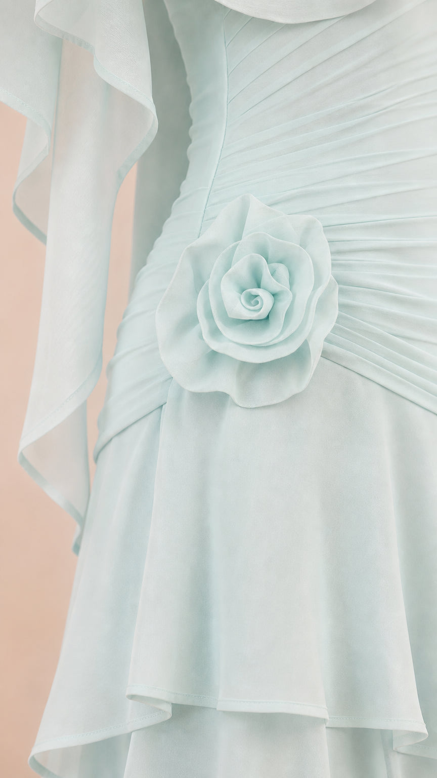 Close-up of waist rosette and pleated bodice detail on light blue dress