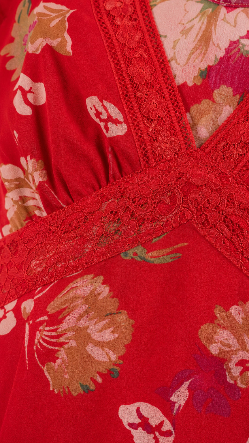 Close-up detail of lace trim and floral fabric on red dress