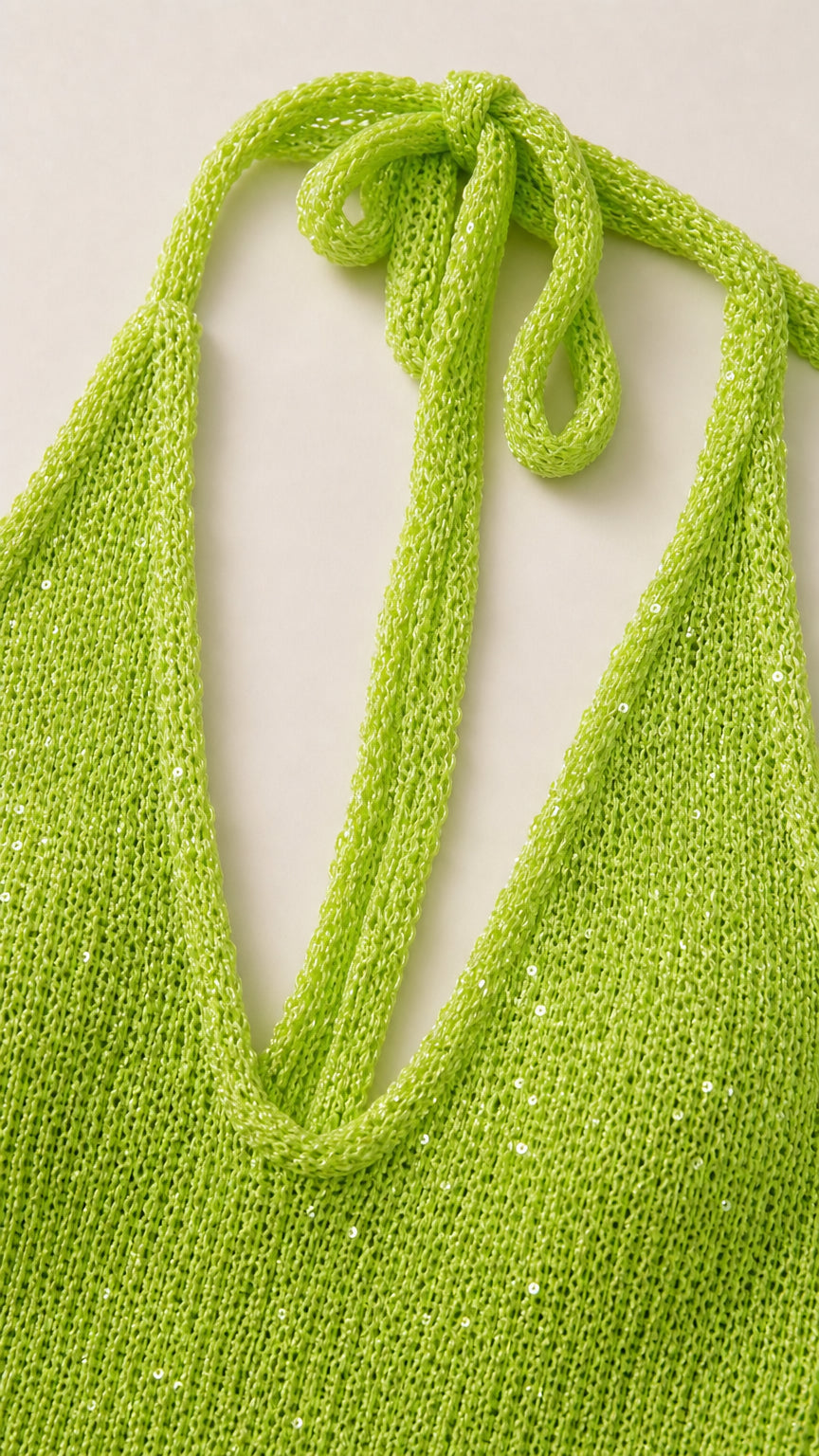 Close-up detail of shimmering neon green knit fabric and halter tie straps