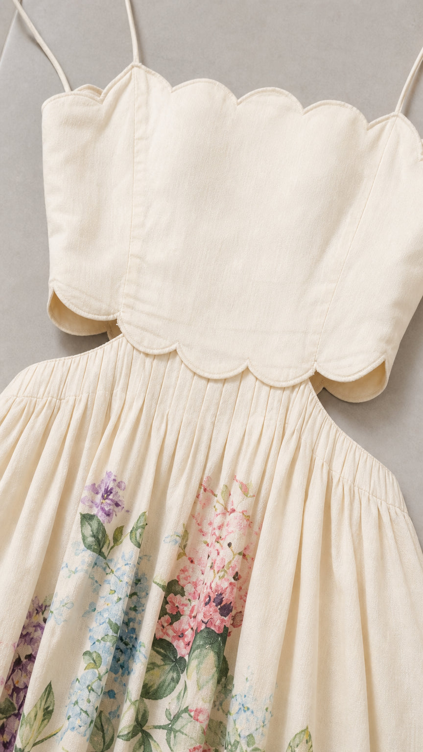 Close-up of ivory dress bodice with scalloped neckline and cutouts