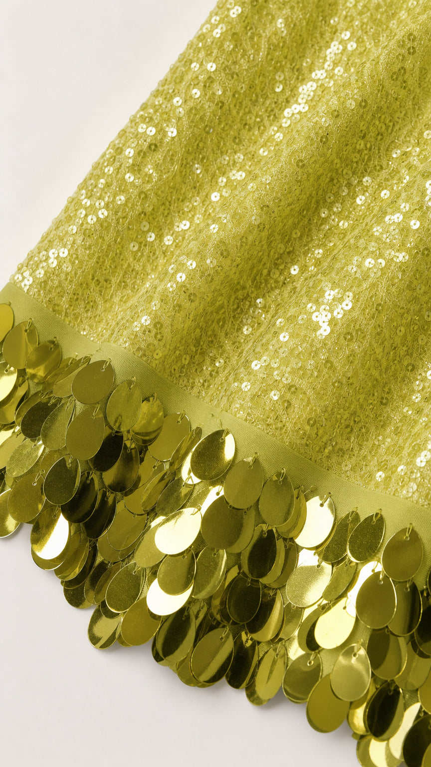 Close-up detail of oversized sequin hem on lime dress